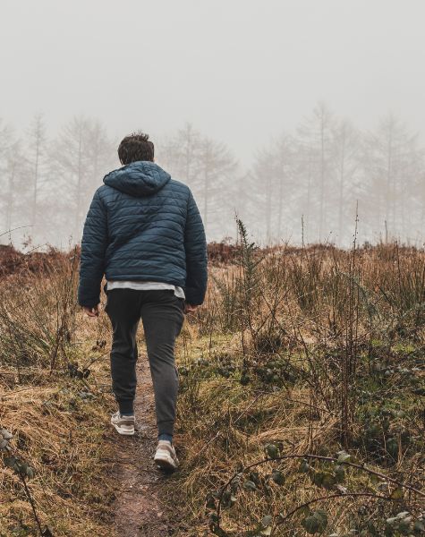 A man hikes in overcast weather.