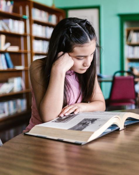 A young girl reads a book.