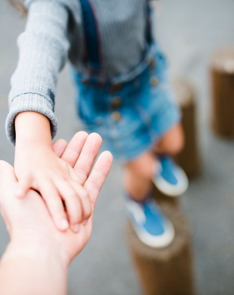 A child holds their parent's hand.